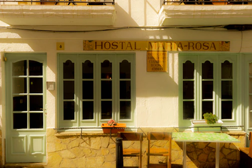 The hostal’s charming exterior illuminated by warm evening lights.