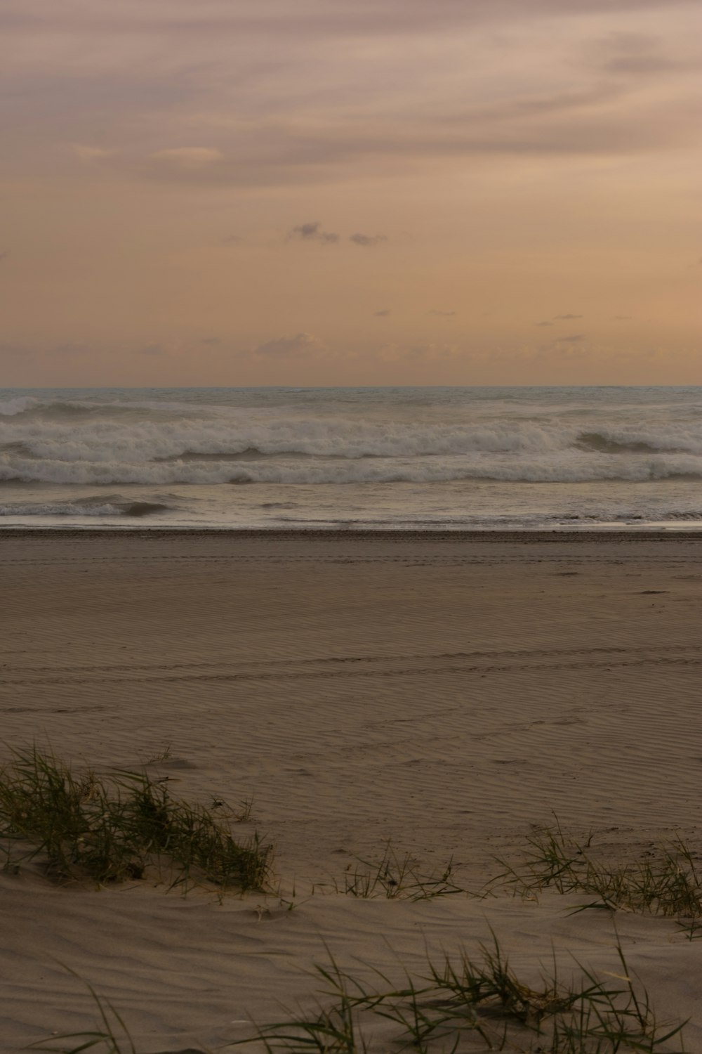 a person walking on a beach with a surfboard