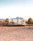 A spacious family camping trailer set up at a sunny campsite