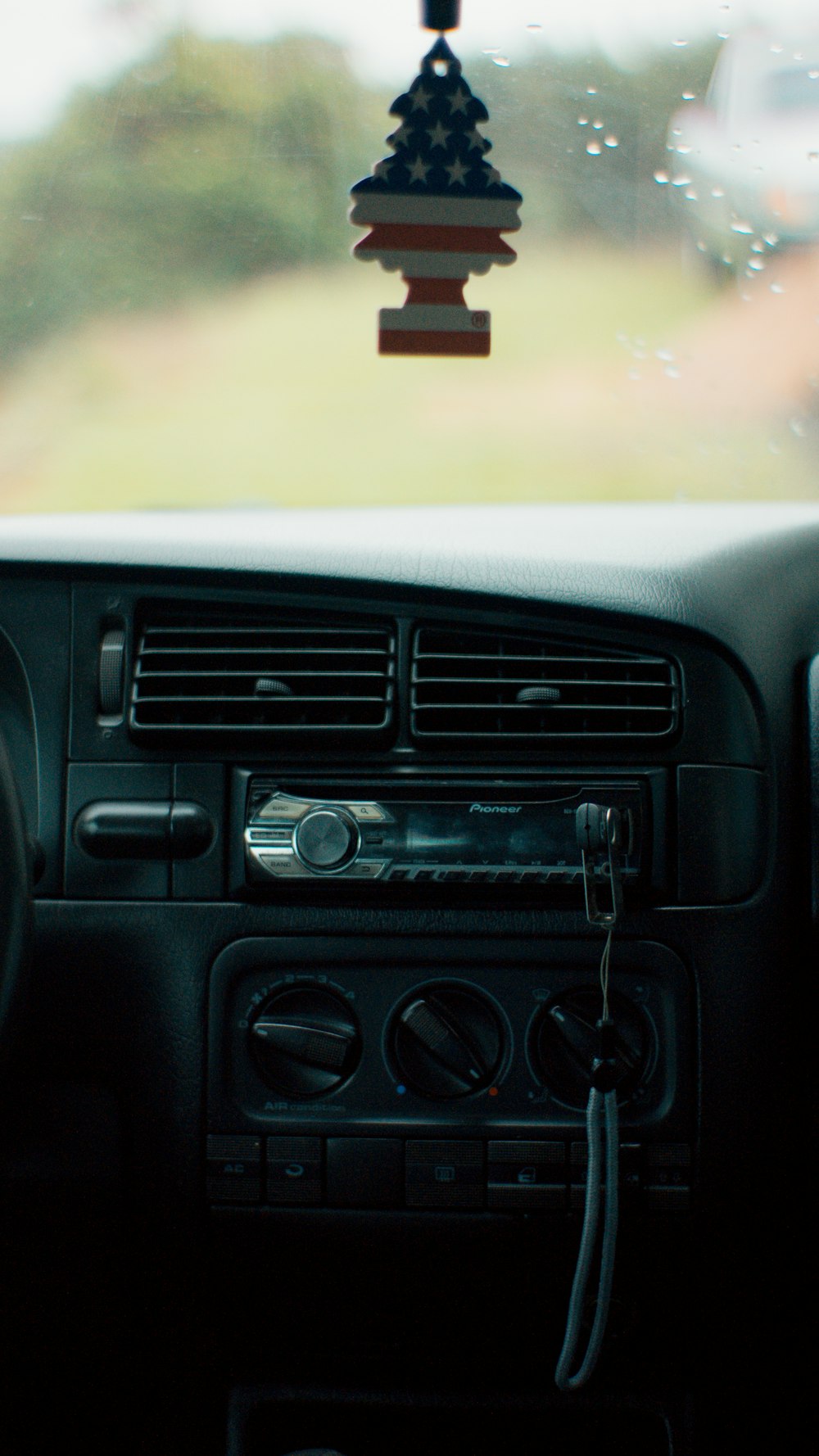 a car dashboard with an american flag decoration hanging from the dash