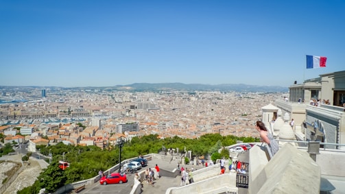 A scenic view of Avignon with vehicles in the foreground.