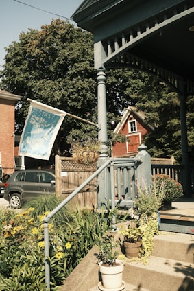 A warm, inviting front porch of a classic Missouri rest home surrounded by blooming flowers.