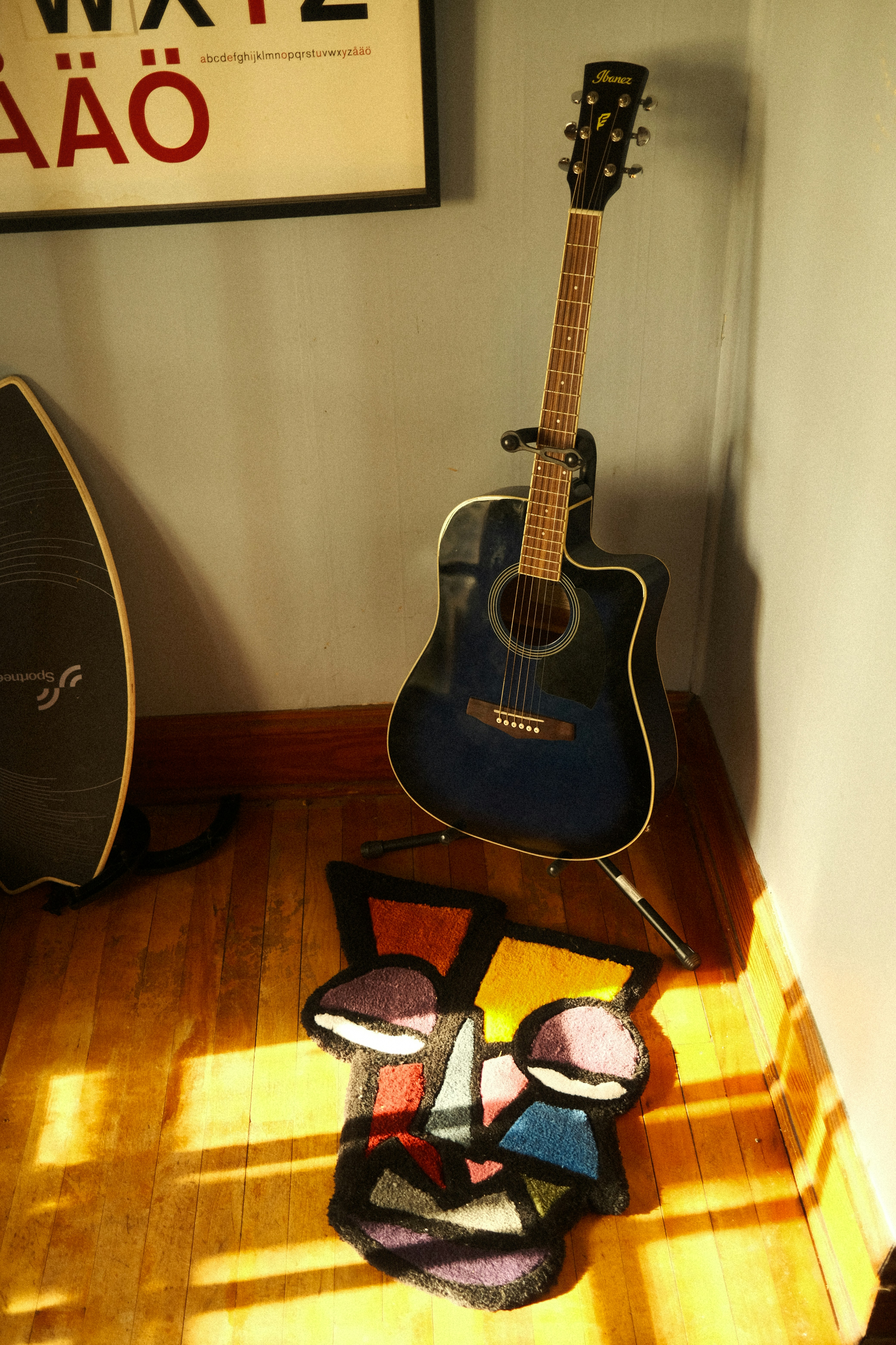 a guitar sitting on top of a hard wood floor