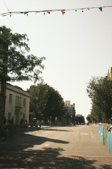 A peaceful street in Berck with a hospital building and event banners in the background.