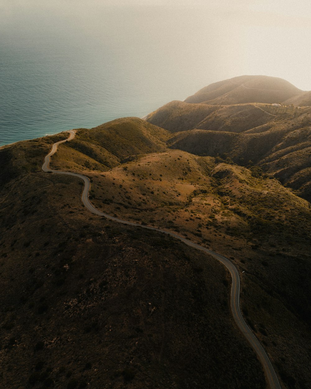 an aerial view of a winding road in the mountains