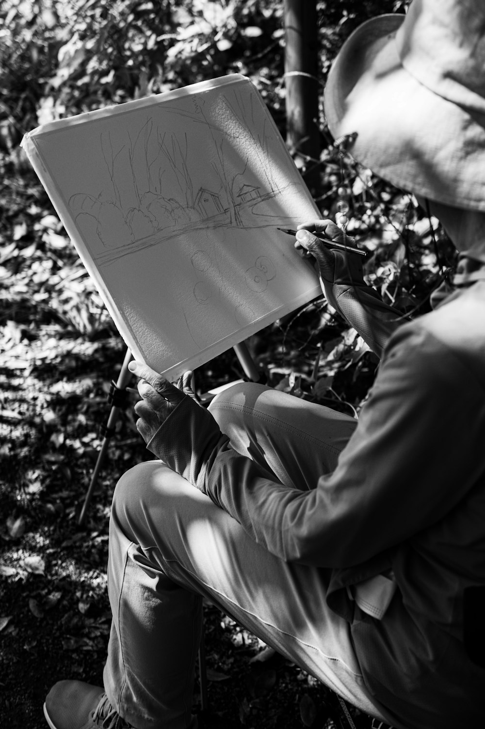 a man sitting on a bench writing on a piece of paper