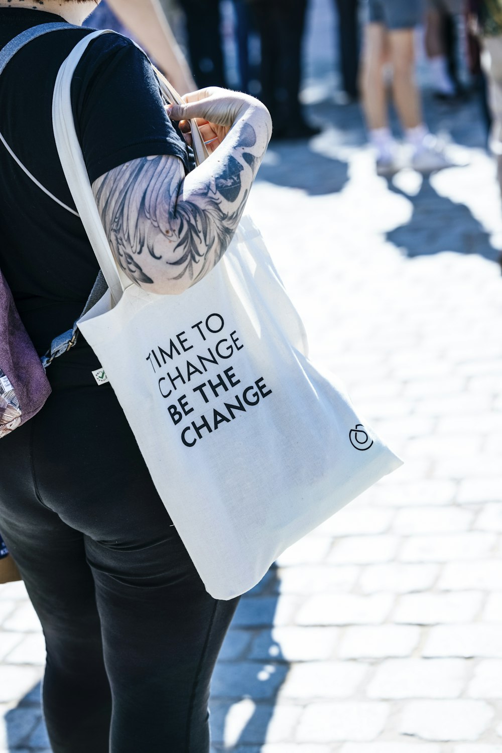 une femme portant un sac avec un message dessus