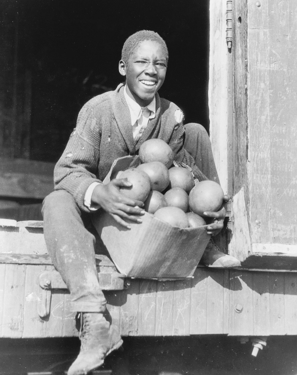 Unloading a carload of oranges and grapefruit, donated to the Red Cross at Lake Wales, Florida, and unloaded for the drought sufferers around Cleveland, Miss. Summary Youth holding box of grapefruit on railroad car.