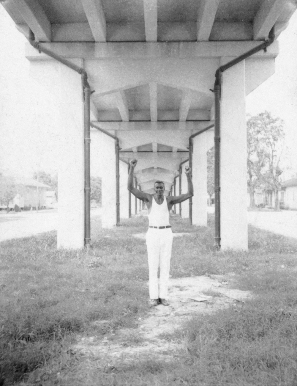 John Bray, standing with hands raised underneath a bridge, Amelia, Louisiana.