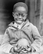 A joyful child holding a personalized toy with a big smile.