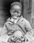 A joyful child receiving a gift, highlighting the impact of donations.