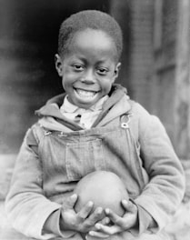 A cheerful child holding a playful toy gift with a big smile.