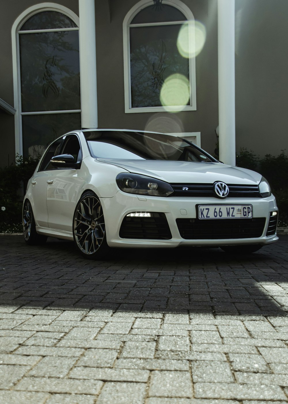 a white car parked in front of a house