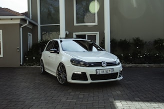 a white car parked in front of a house