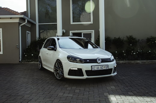 a white car parked in front of a house