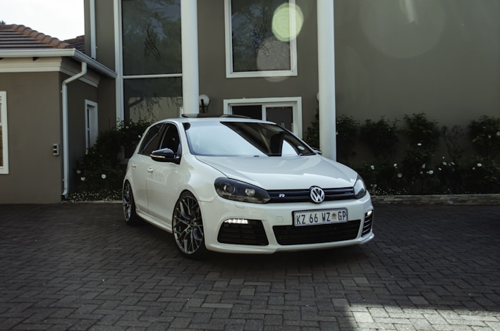 a white car parked in front of a house