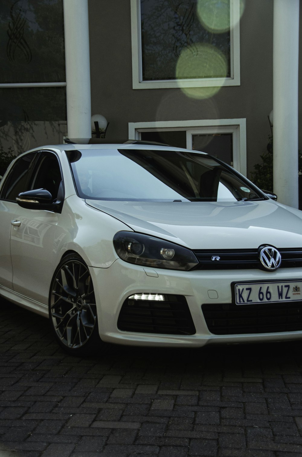 a white car parked in front of a house