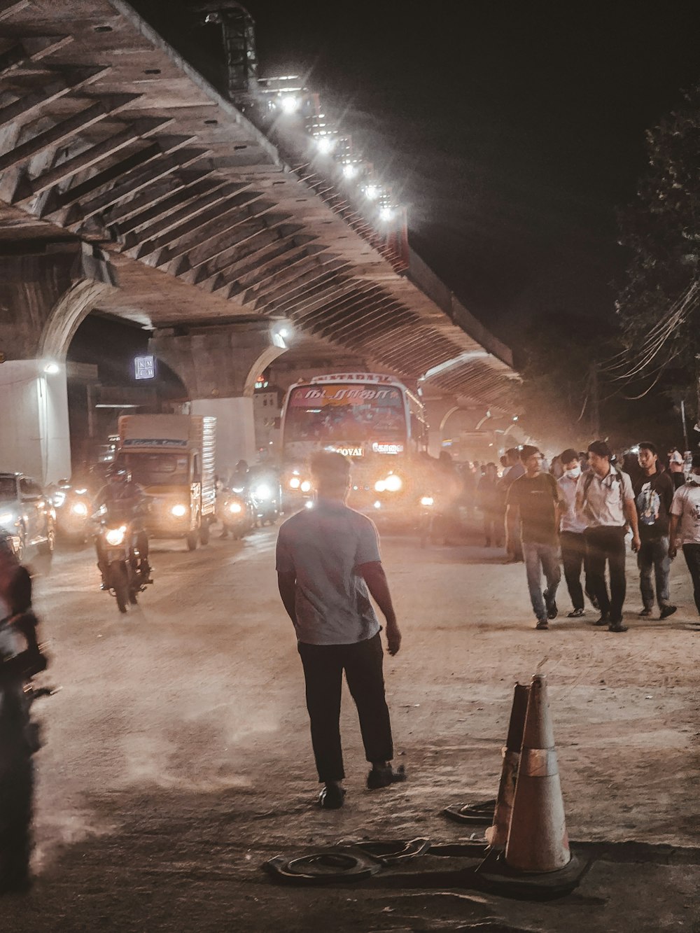 a group of people walking down a street at night