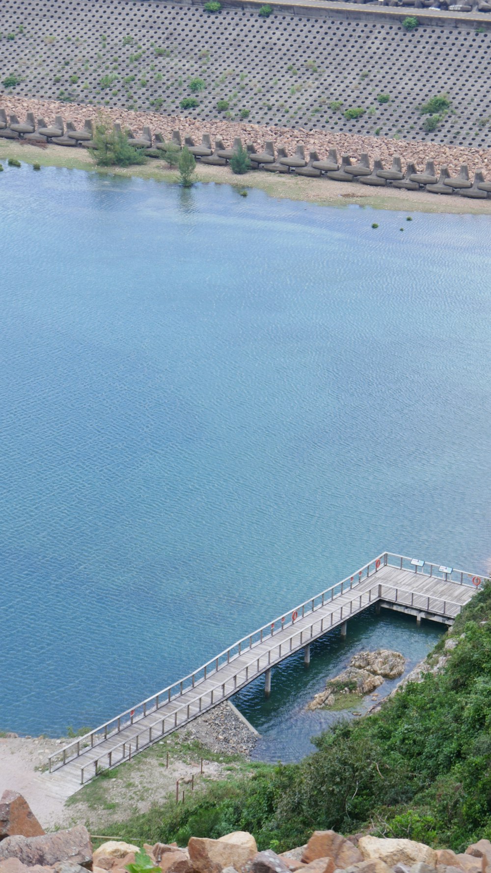 a large body of water next to a wooden bridge