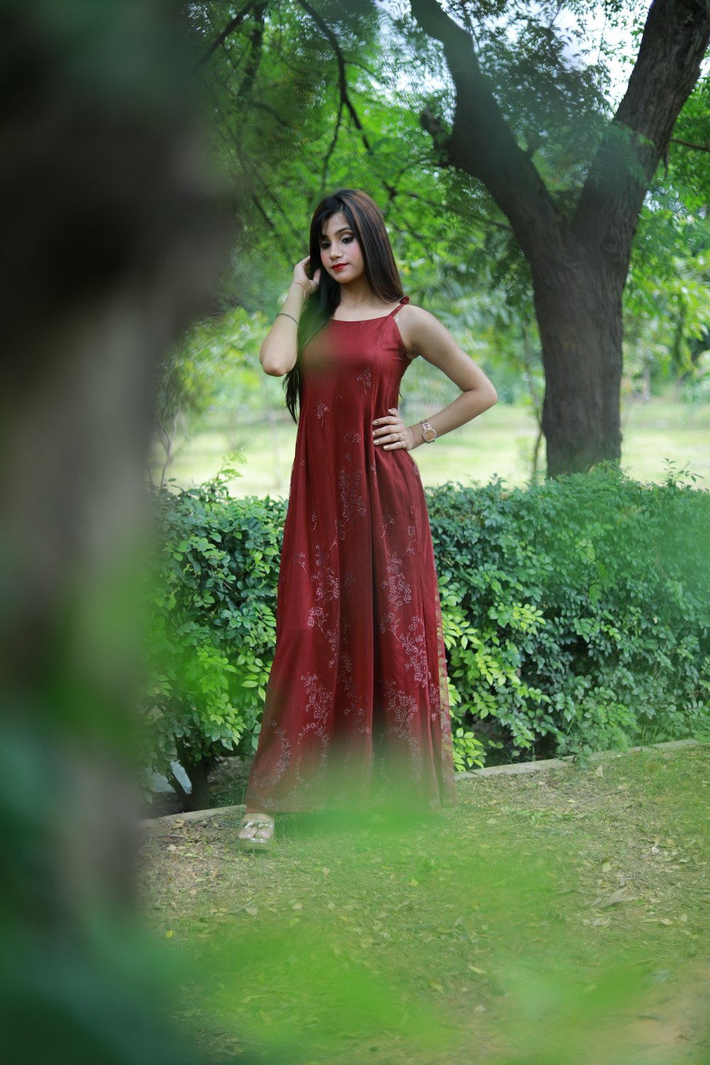 a woman in a red dress standing in the grass