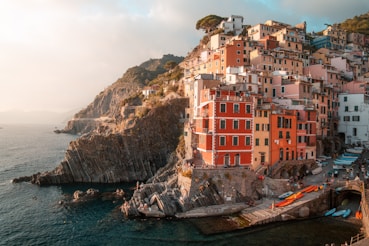 a group of buildings sitting on top of a cliff next to the ocean