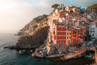 a group of buildings sitting on top of a cliff next to the ocean