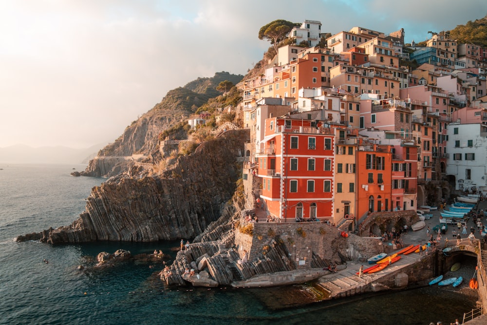 a group of buildings sitting on top of a cliff next to the ocean