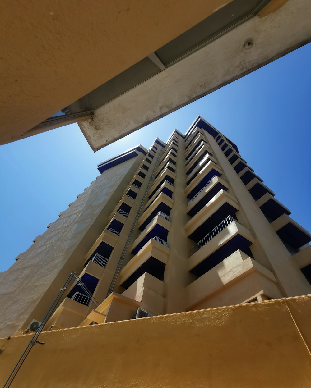 looking up at a tall building with balconies
