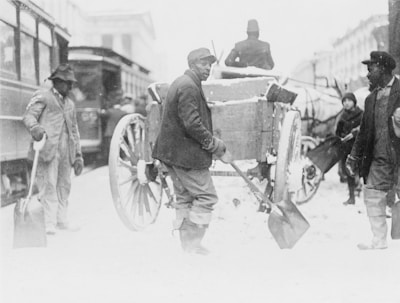 Crew members shoveling a sidewalk, bundled up against the cold.
