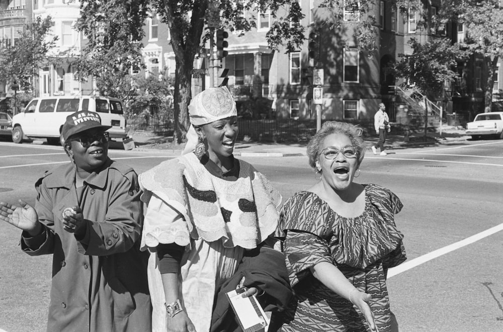 Three African American women singing and walking in a street in the Capitol Hill neighborhood, the day of the Million Man March in Washington, D.C.