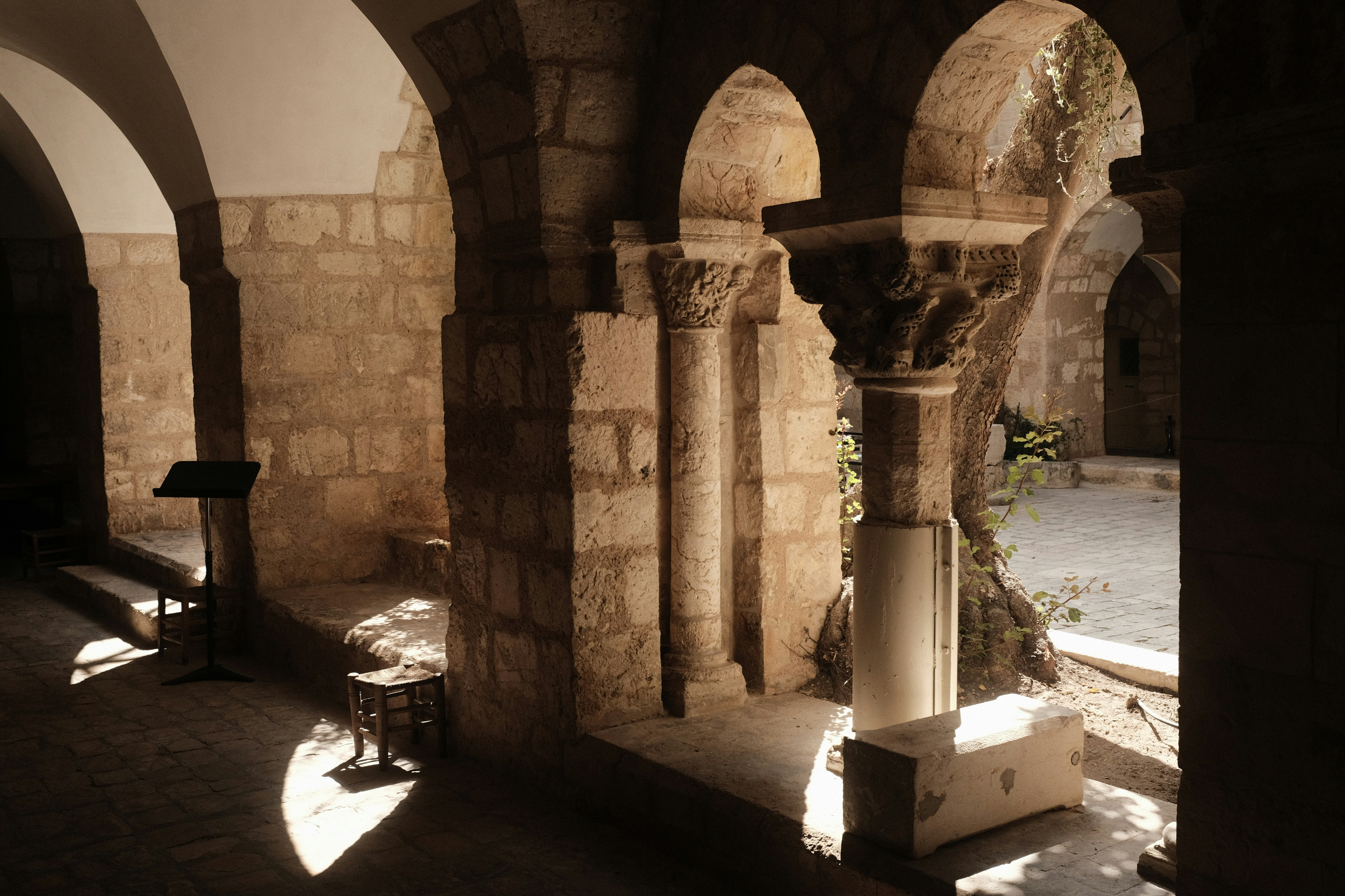 a room with arches and a bench in it, Cloister