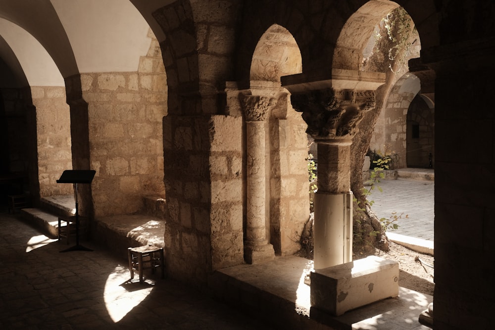 a room with arches and a bench in it