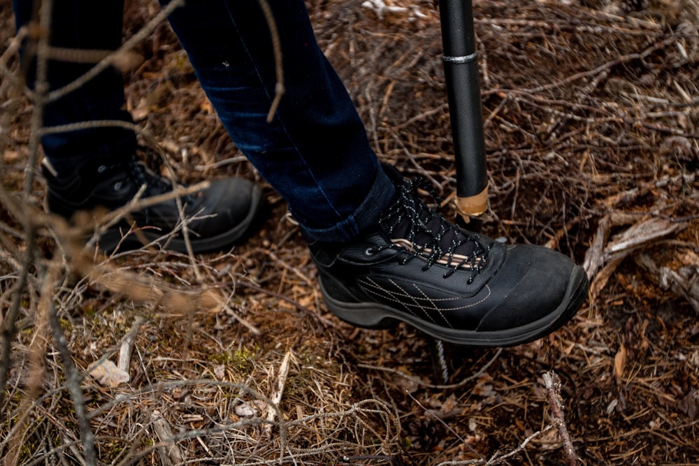 a person standing in the woods with a walking stick