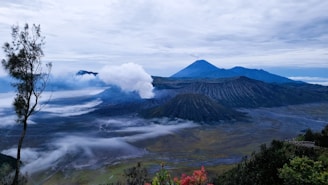 a view of a mountain range with clouds in the air