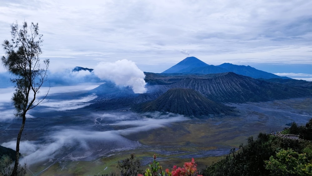 a view of a mountain range with clouds in the air