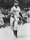 A baseball player in mid-action about to throw a pitch. The athlete is wearing a uniform with 'March' written on the jersey, and a cap. In the background, a crowd is visible, likely in a stadium setting.