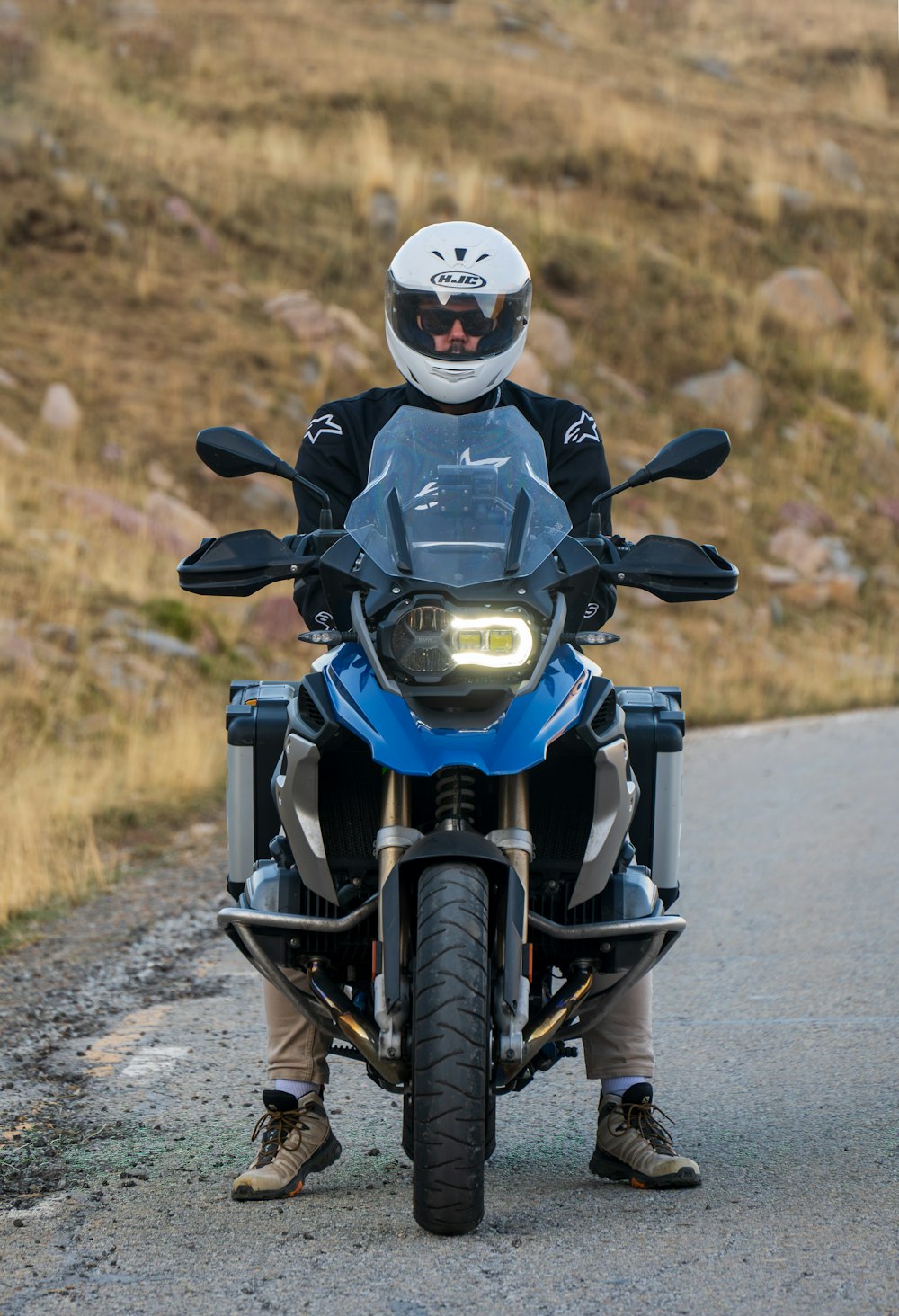 a man riding a motorcycle down a country road