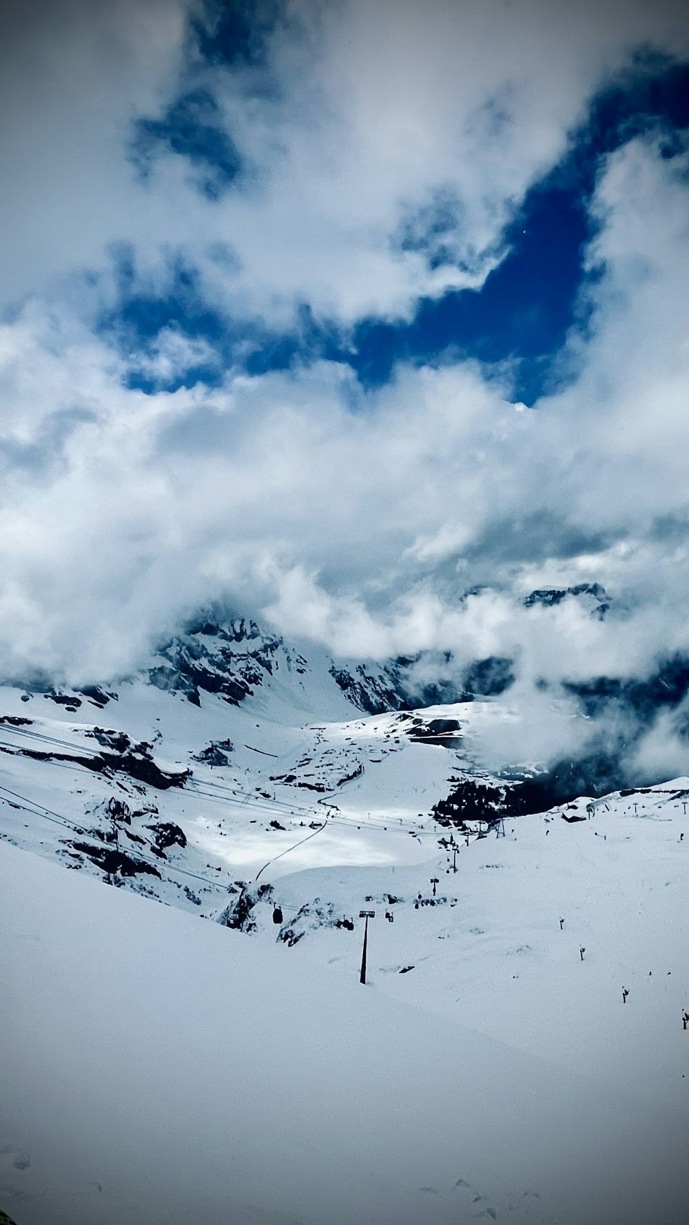 a mountain covered in snow under a cloudy sky