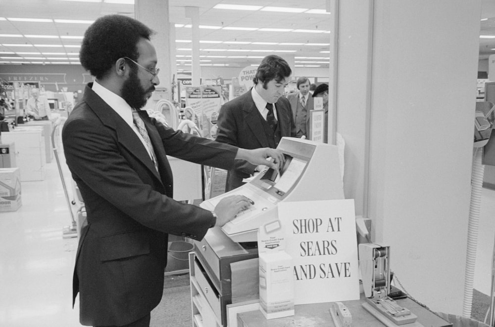 African American man at a cash register in a Sears department store.