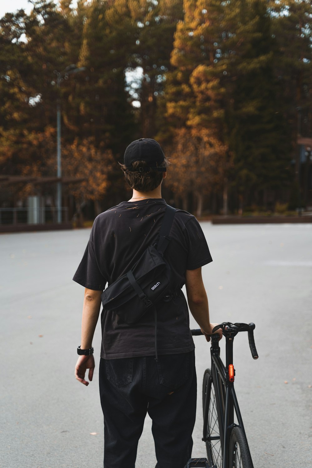 a man standing next to a bike in a parking lot