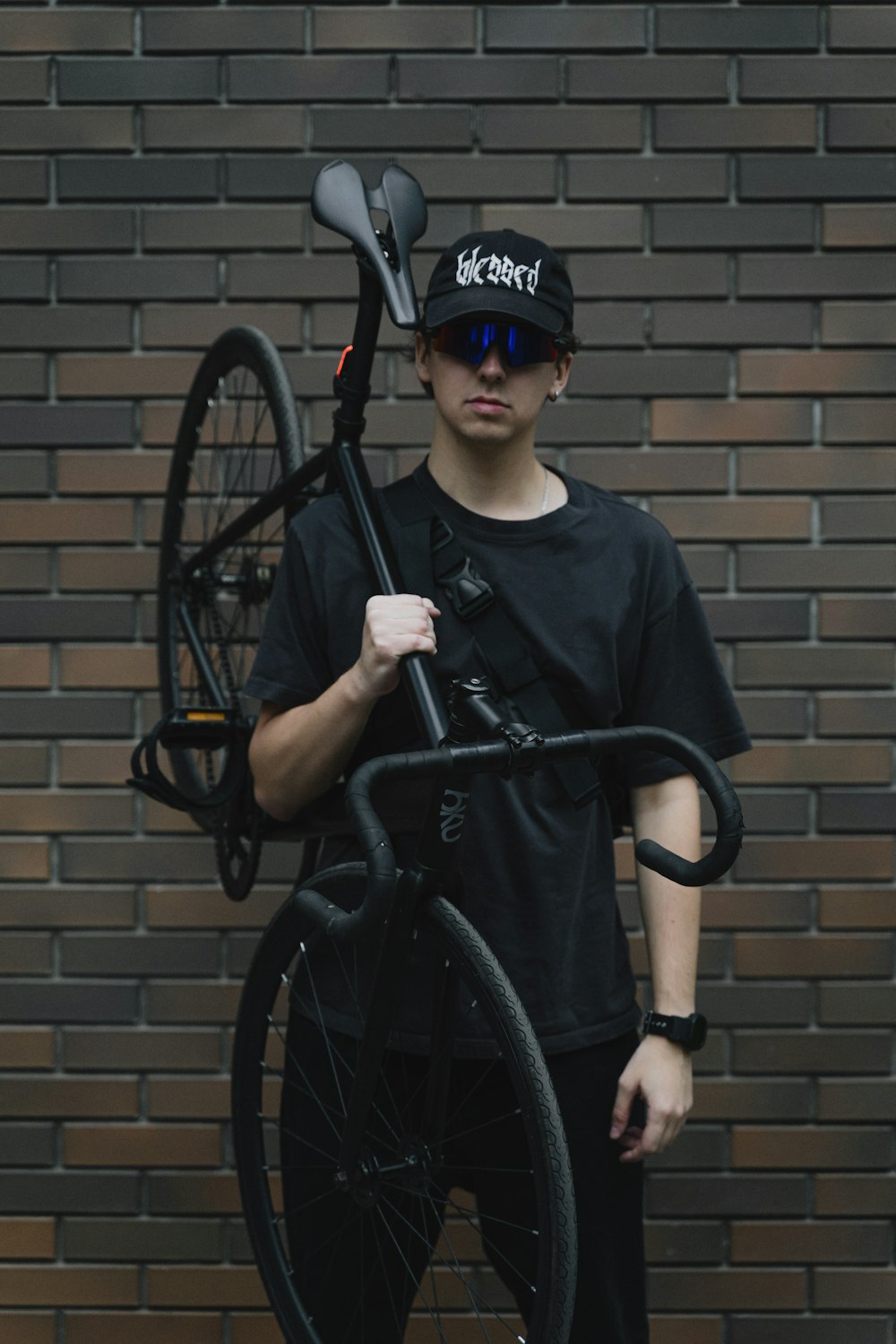 a man holding a bike with a hat on his head