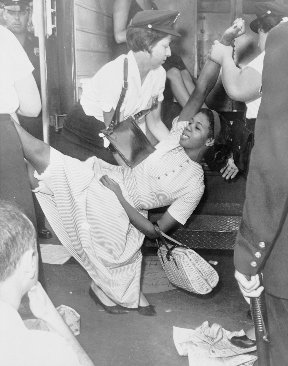 African American woman, Juanita Sealy, being carried to police patrol wagon during demonstration in Brooklyn, New York.