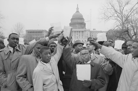 African American men with signs stand in front of the U.S. Capitol, probably in support of the Civil Rights Act of 1960.