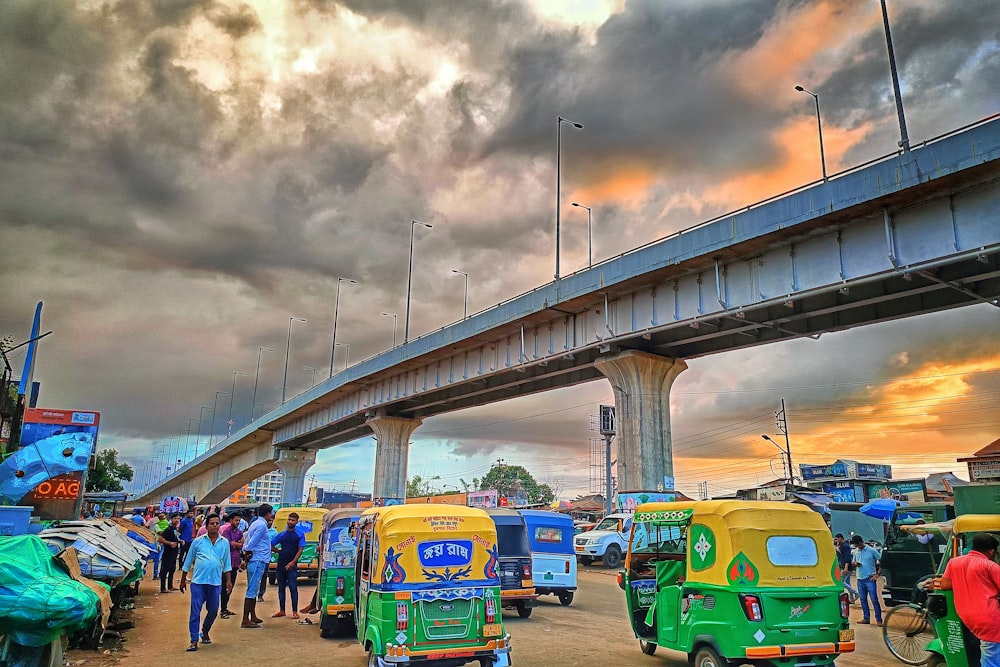 a group of vehicles parked next to each other under a bridge