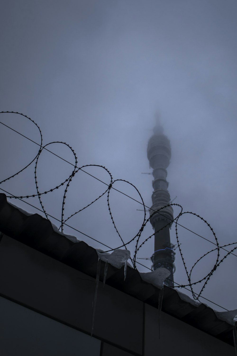 a tall tower with barbed wire on top of it
