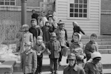 A group of children receiving warm clothing during a chilly day.