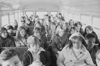 A group of happy students boarding a comfortable travel bus.