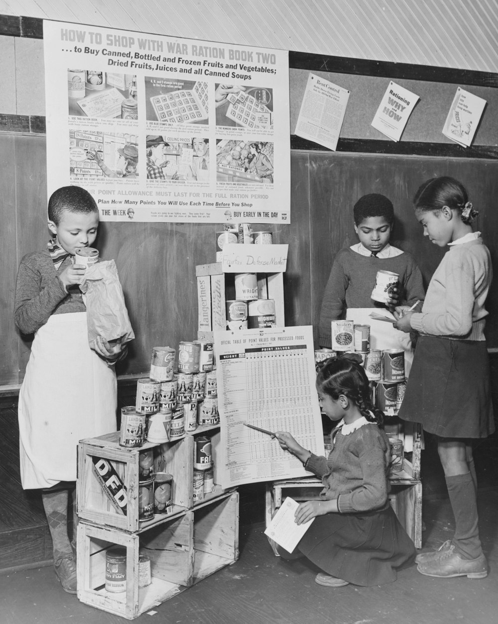 African American children learning about war rationing at school] Summary Photograph shows boys pretending to be grocers and girls pretending to be shoppers at pretend grocery market at school in Washington, D.C.