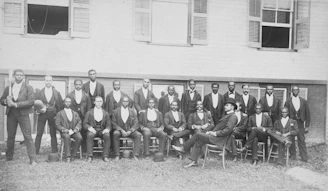African American baseball team, Danbury, Connecticut] Summary Photograph showing 23 men wearing suits, sitting and standing, one holding a baseball bat; they are members of an African American men's baseball team, possibly in Danbury, Connecticut.