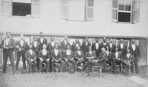 African American baseball team, Danbury, Connecticut] Summary Photograph showing 23 men wearing suits, sitting and standing, one holding a baseball bat; they are members of an African American men's baseball team, possibly in Danbury, Connecticut.